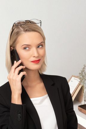 A woman in a business suit talking on a cell phone