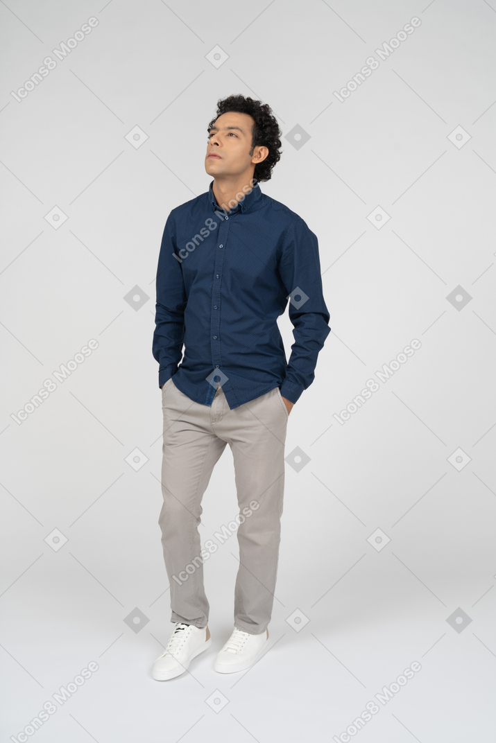 Vista frontal de un hombre en ropa casual de pie con las manos en los bolsillos