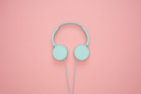 Blue headphones over pink pastel background