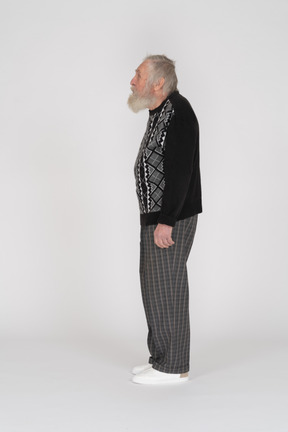An elderly man standing sideways