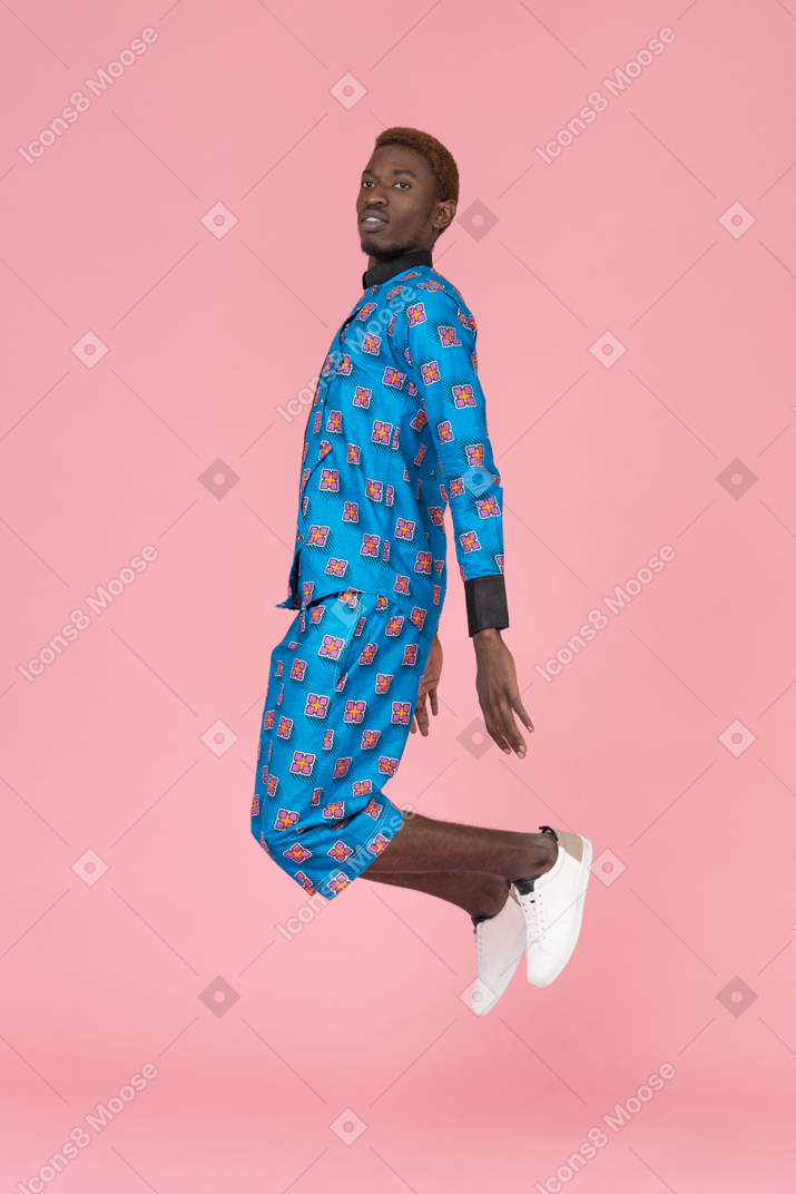 Homem negro pulando no fundo rosa