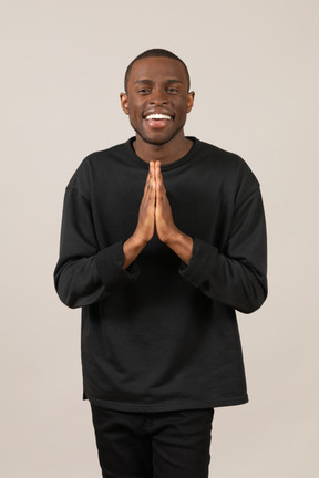 Jeune homme reconnaissant avec les mains jointes