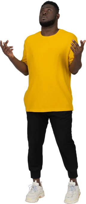 Front view of a young dark-skinned man in yellow t-shirt standing still