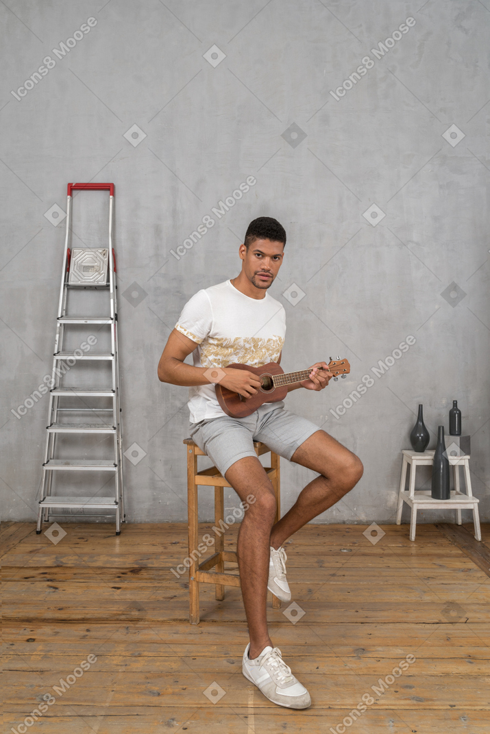 Three-quarter view of a man posing with ukulele
