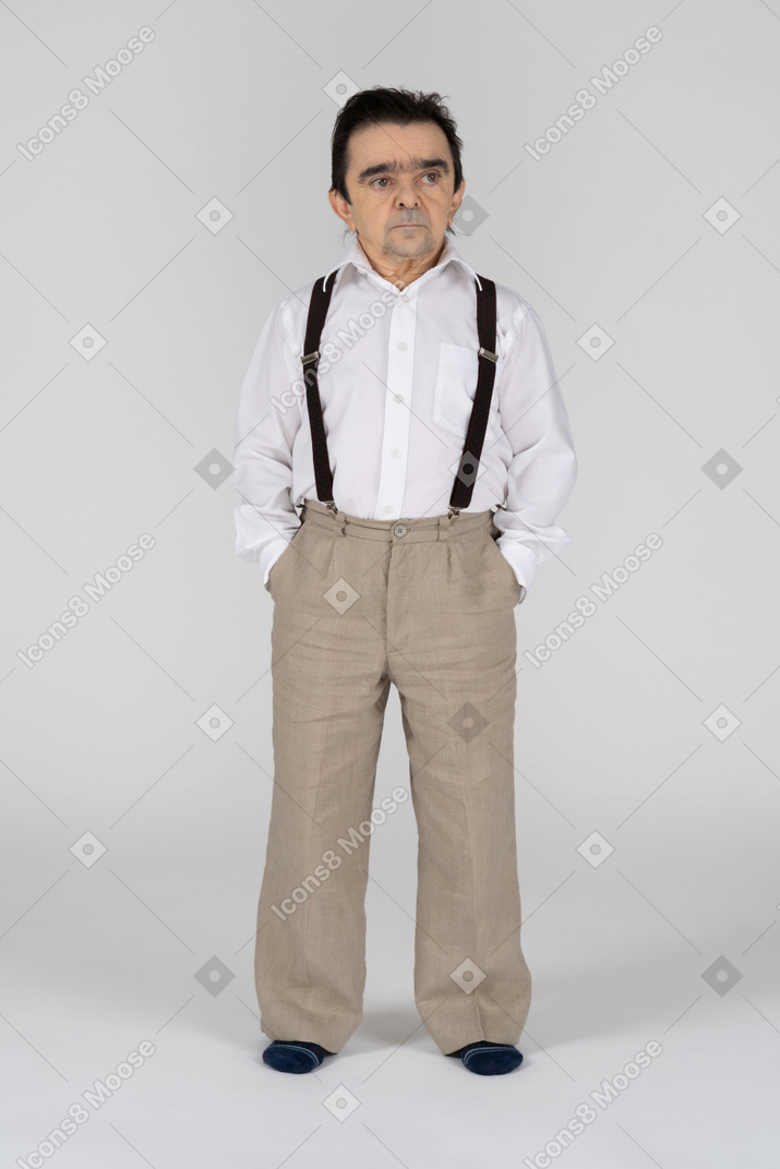 Homem de meia idade com as mãos nos bolsos olhando de lado