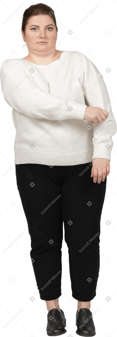 Front view of a plus size woman in casual clothes rolling up her sleeve