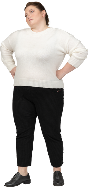Angry plump woman in casual clothes standing with hands on hips