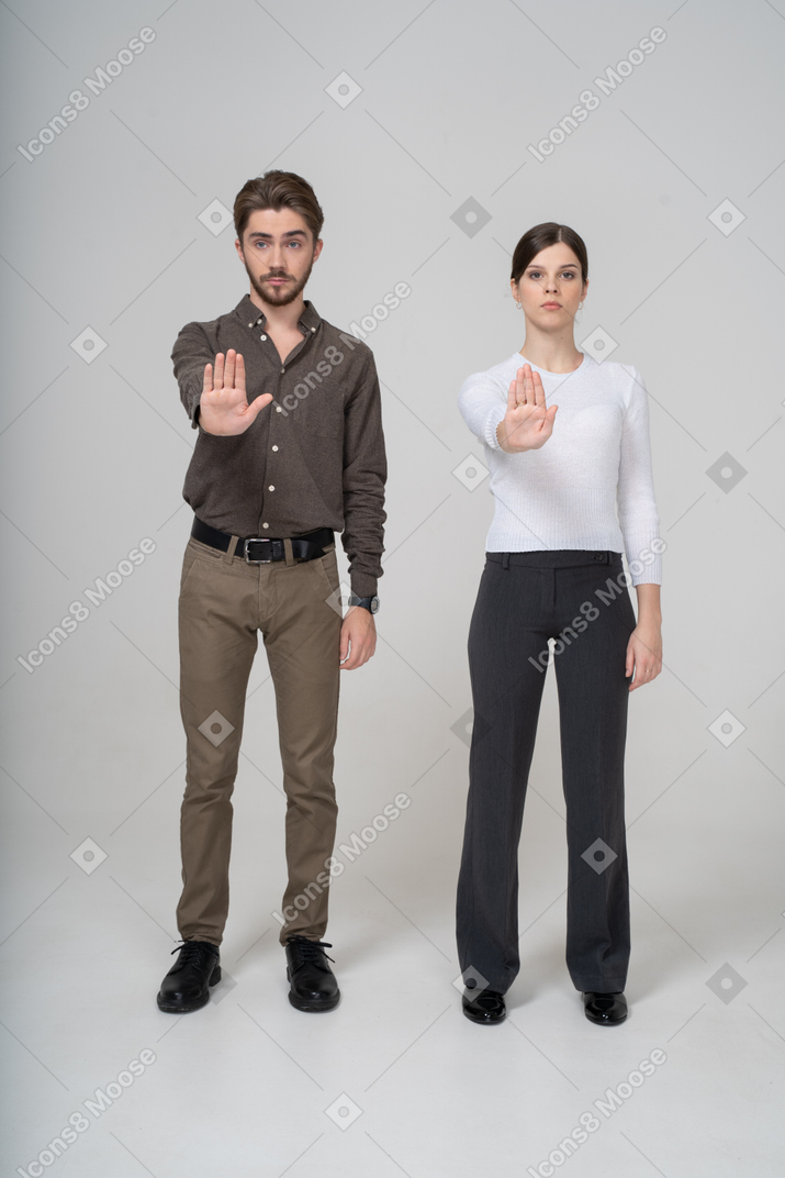 一对年轻夫妇在办公室服装伸出手中的前视图