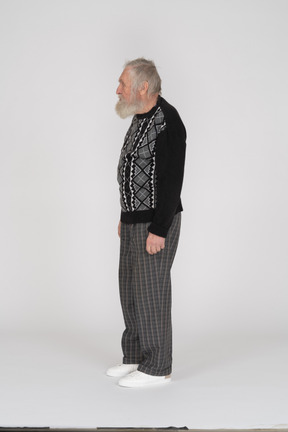Side view of standing elderly man in dark clothes
