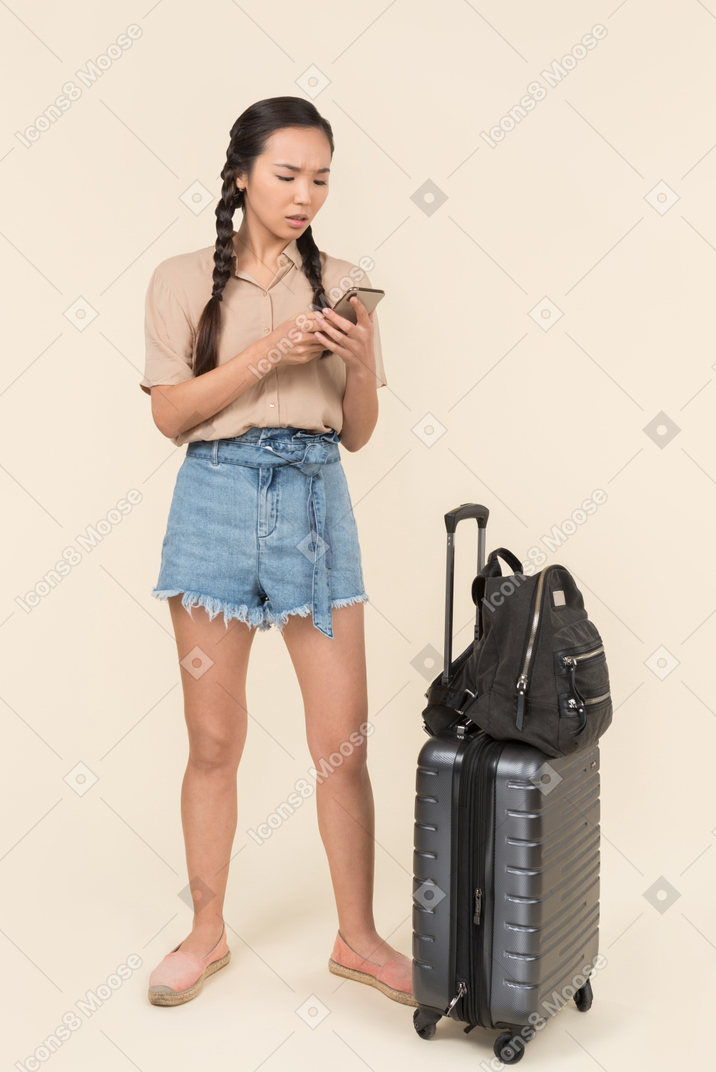 Confused female traveler using her phone