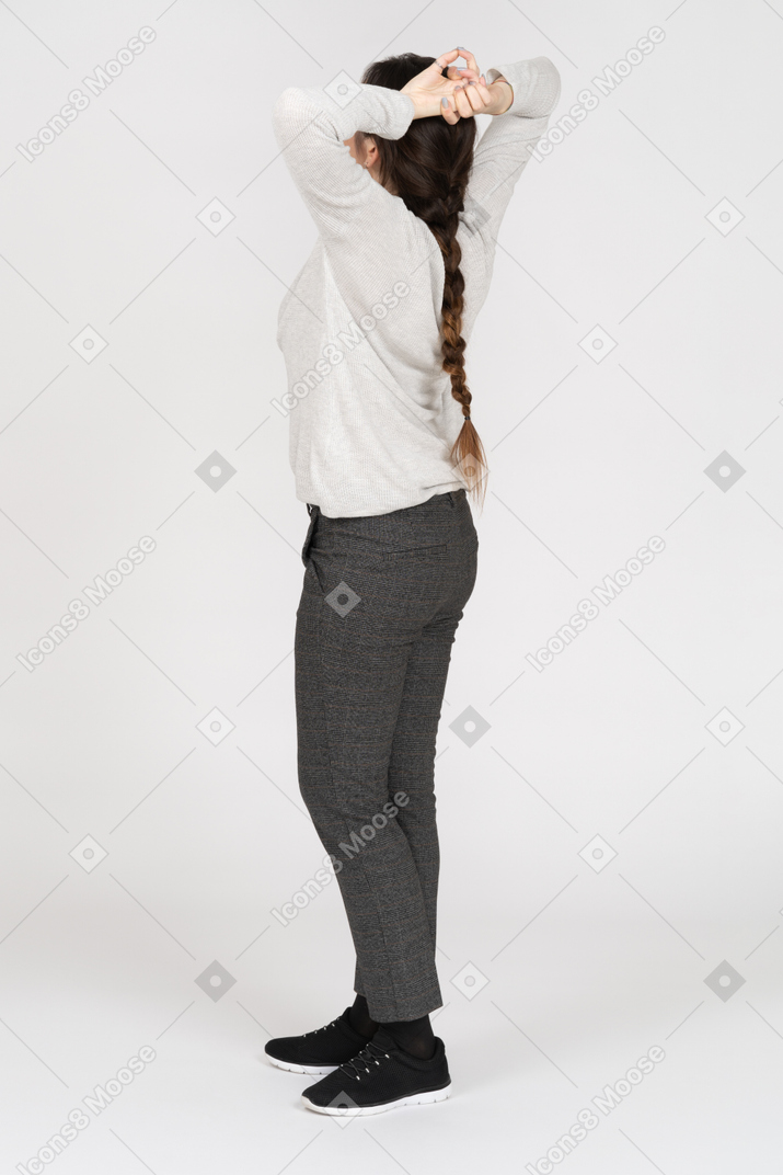 Relaxed brunette female posing with her hands behind the head