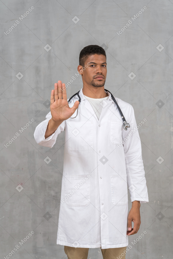 중지 손을 보여주는 남성 의사
