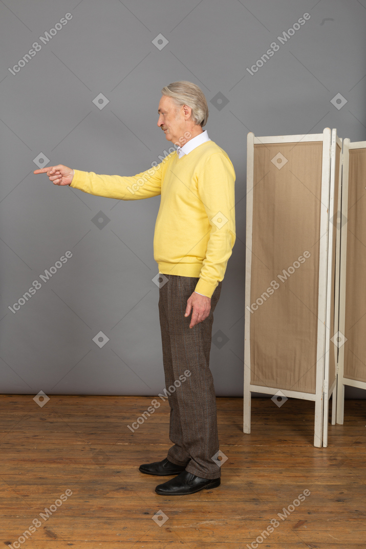 Side view of an old man pointing finger