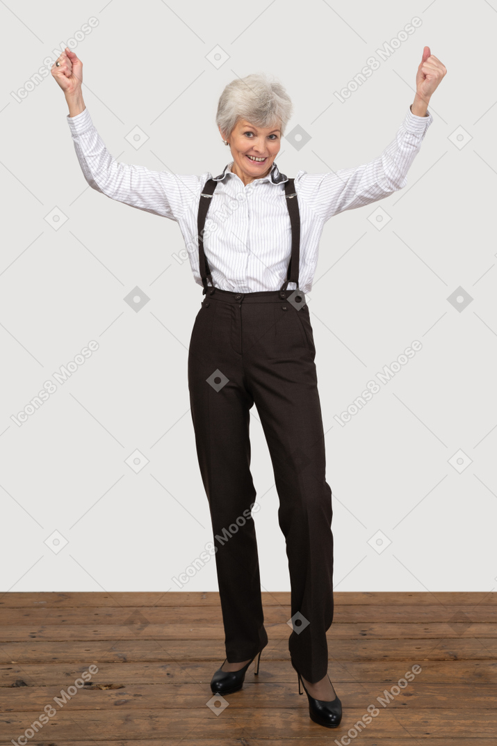 Mujer vestida formalmente celebrando con las manos en alto