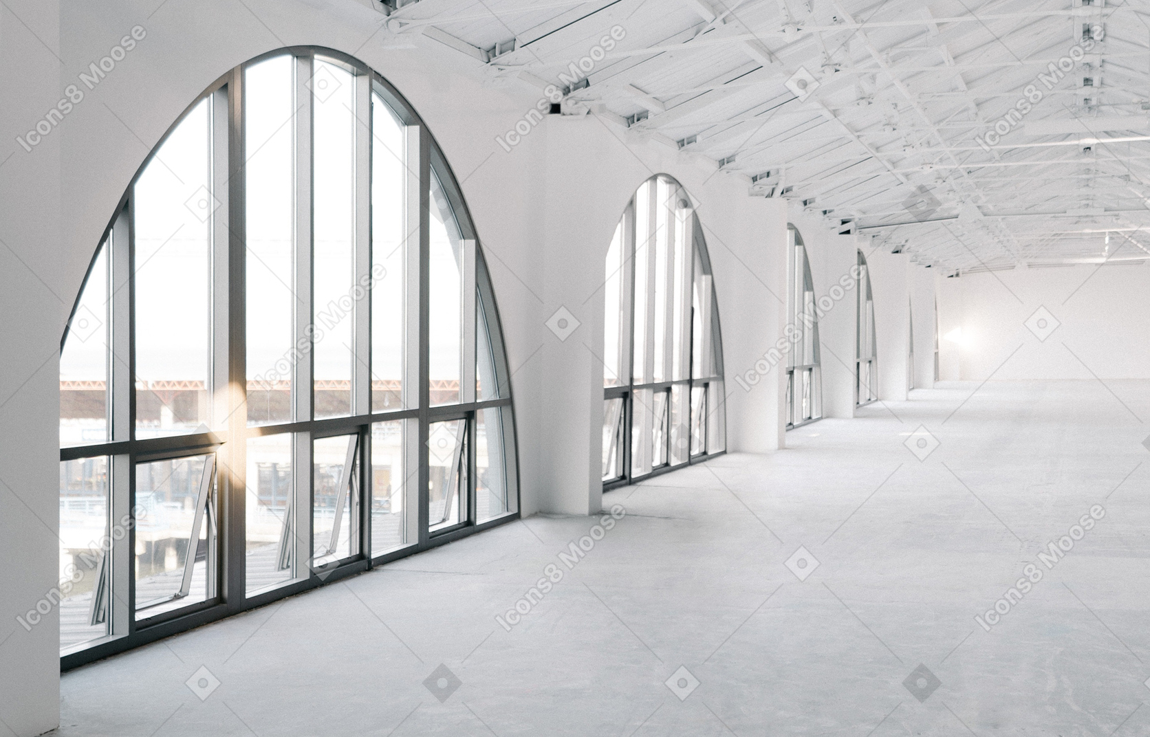 Um grande salão branco vazio com uma fileira de grandes janelas de arco