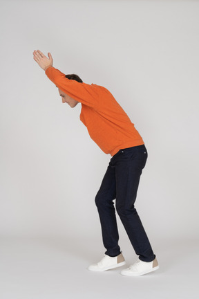 Young man in orange sweatshirt jumping