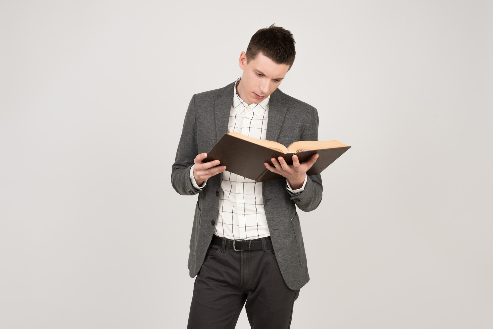 Young man standing and reading a book