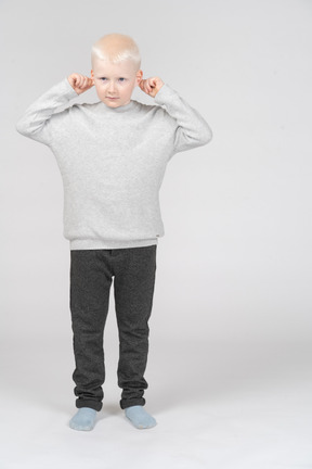 Front view of a boy pulling ears