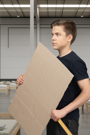 Joven de pie con un cartel en blanco