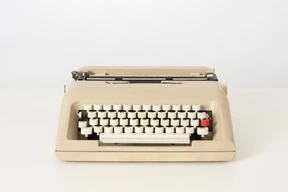 Beige typewriter on a white background