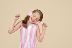 Cute little girl in the headphones listening to a music