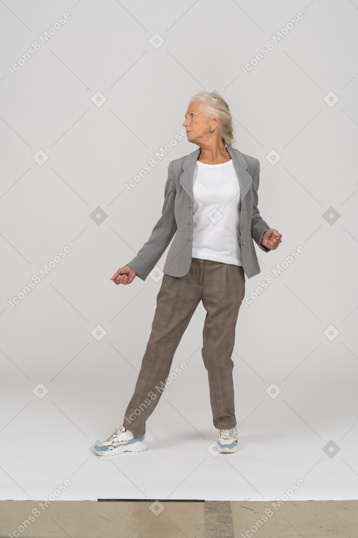 Front view of an old lady in suit dancing