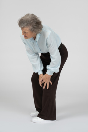 Old woman touching her sore knee