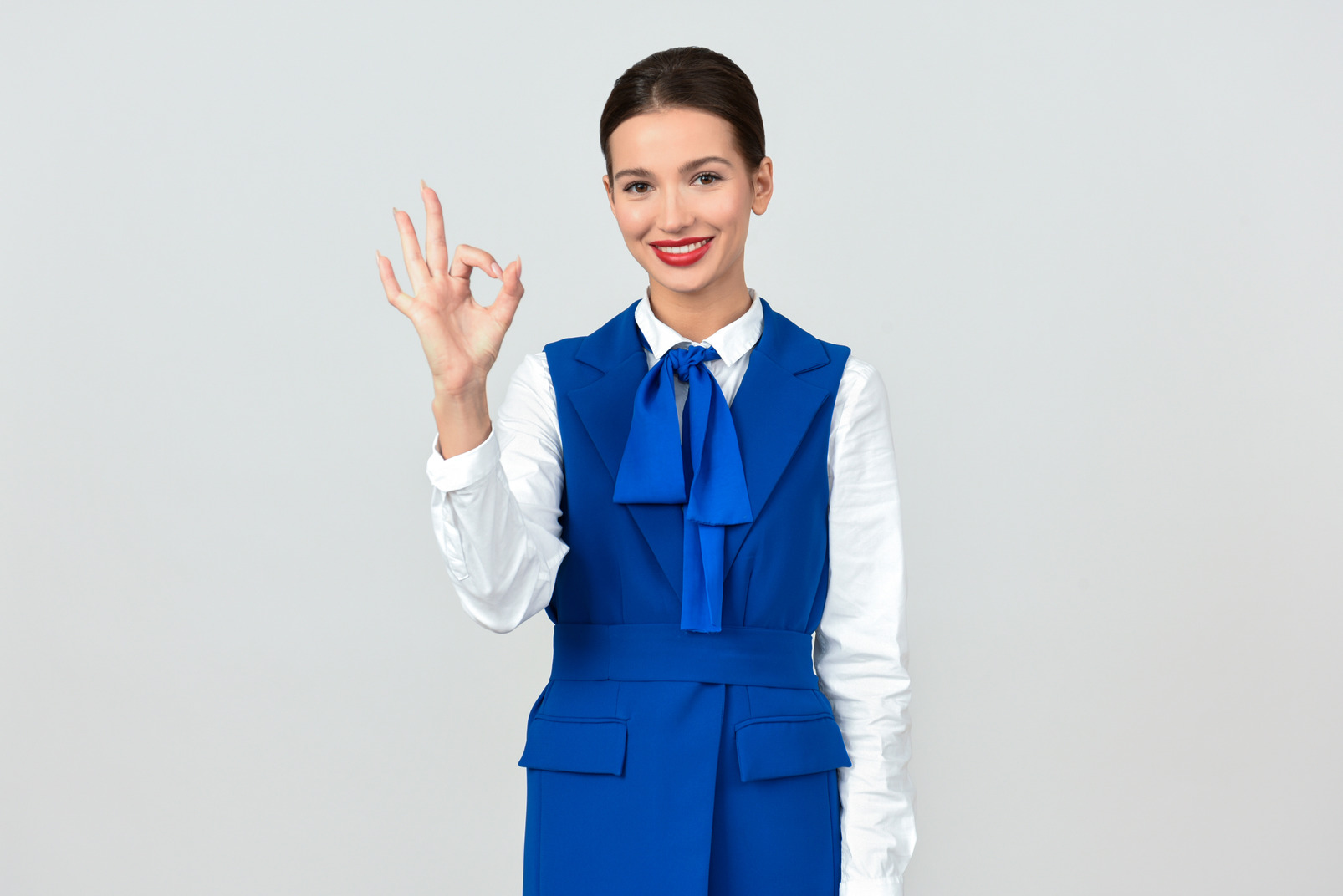 Young flight attendant showing ok sign
