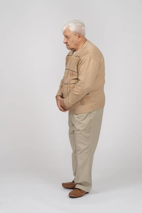 Side view of an old man in casual clothes standing still