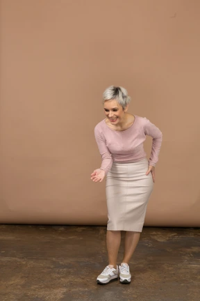 Front view of a happy woman in casual clothes making a welcoming gesture