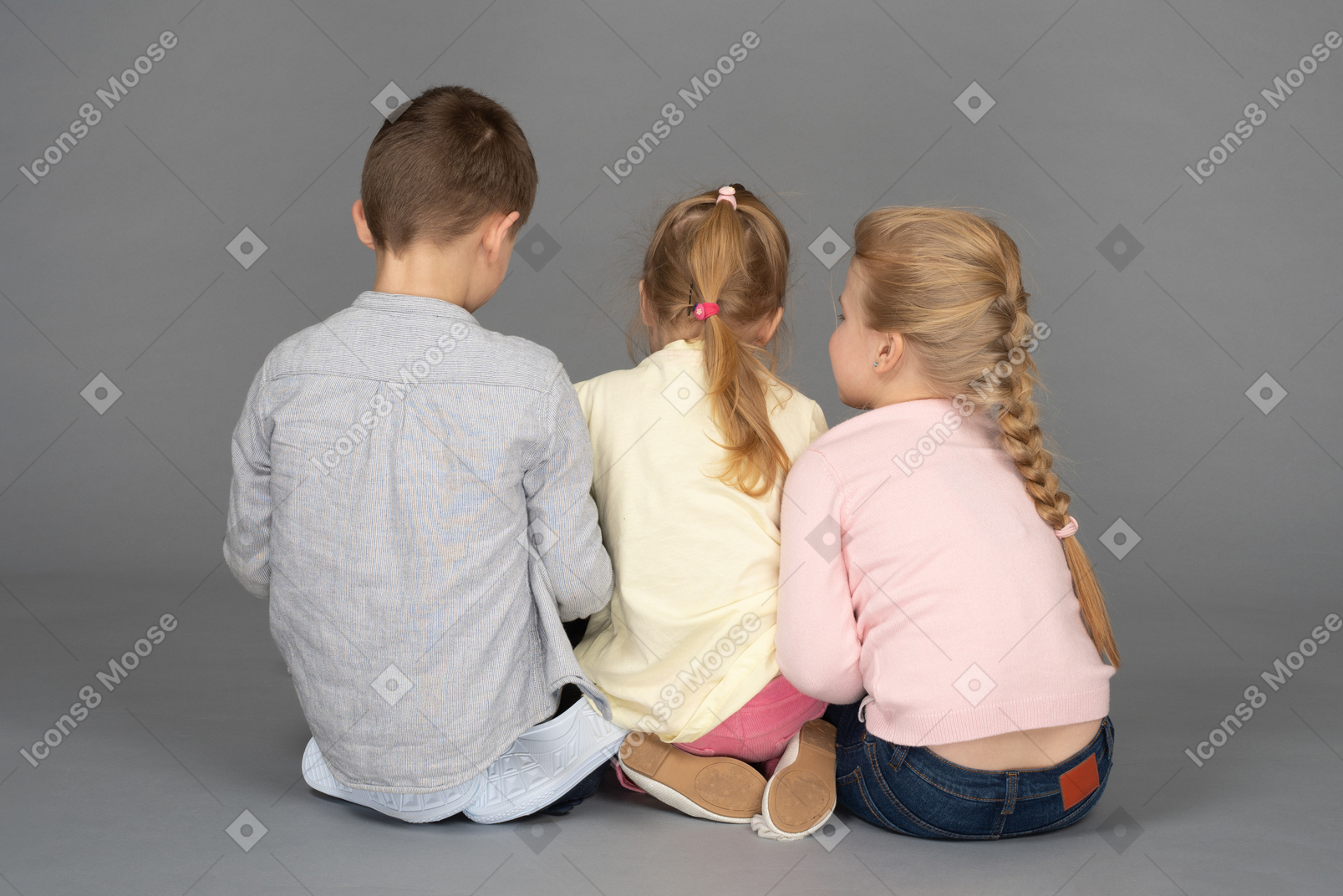 Crianças sentadas de costas para a câmera