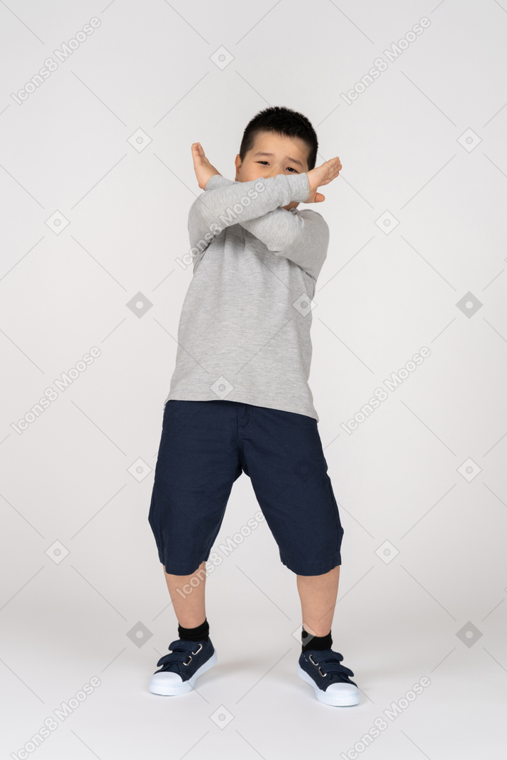 Vista frontal de un niño cruzando los brazos