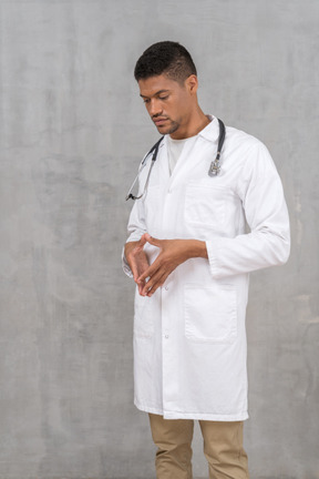 Young doctor steepling his fingers and looking down