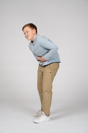 Vista frontal de un niño que sufre de dolor de estómago
