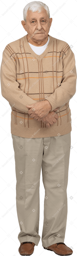 Front view of an old man in casual clothes looking at camera