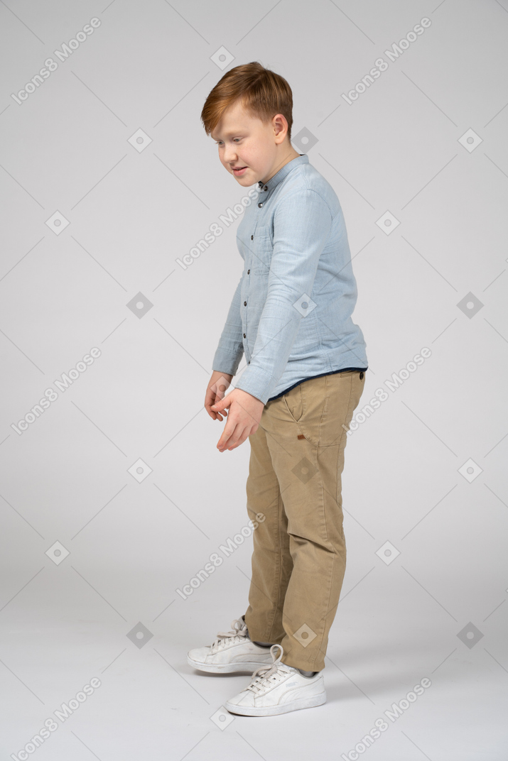 Cute boy bending with extended arm and looking down