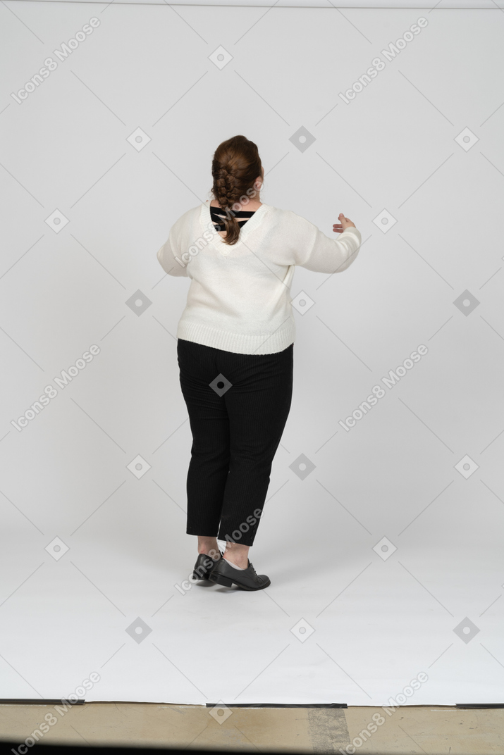 Rear view of a plump woman in white sweater