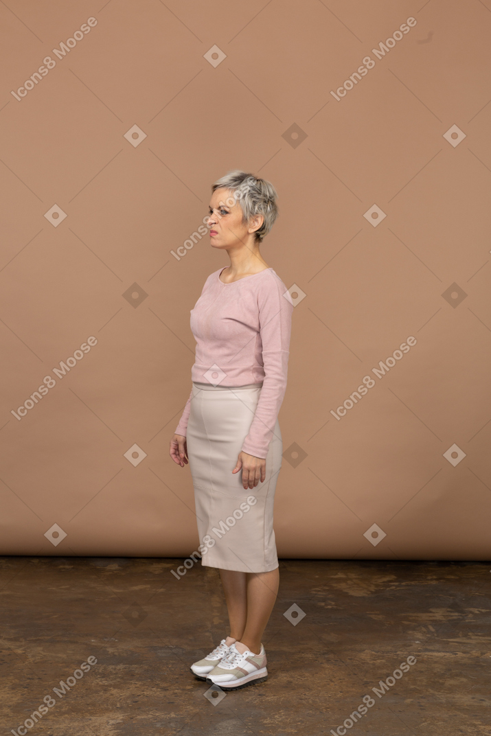Vista lateral de uma mulher com roupas casuais fazendo caretas