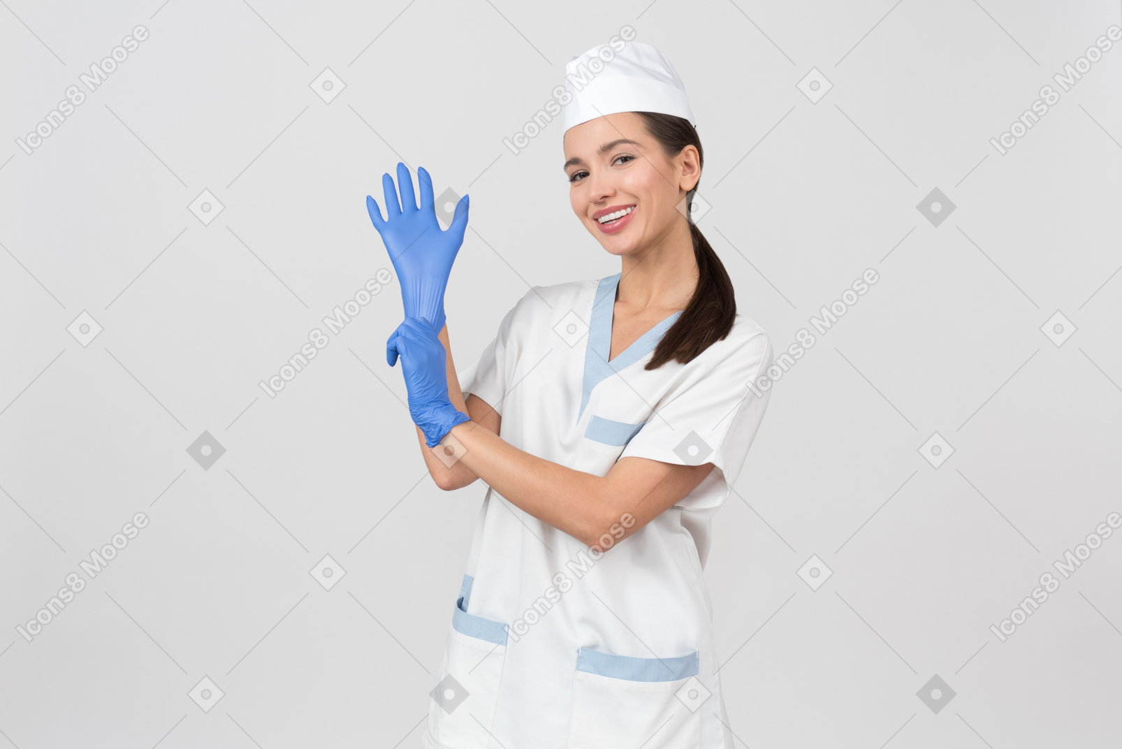 Attractive nurse in a medical robe putting on a latex glove