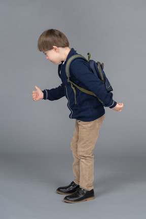 Side view of a schoolboy giving thumbs up