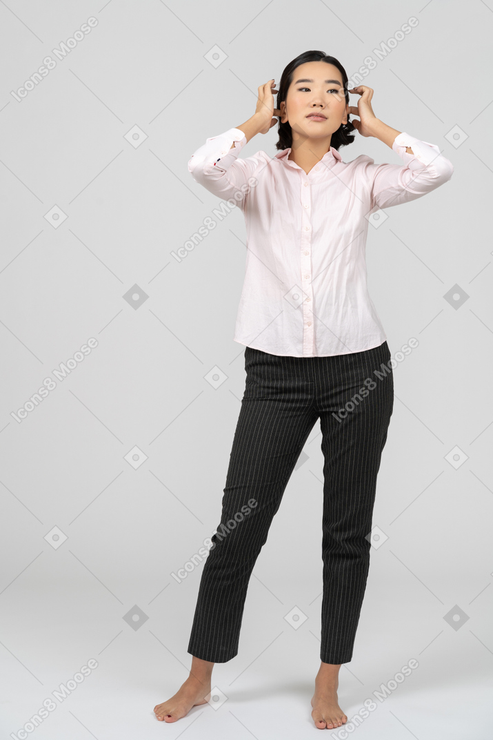 Mujer en ropa de oficina arreglando su cabello
