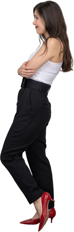 Side view of a grimacing young female in office clothing crossing hands
