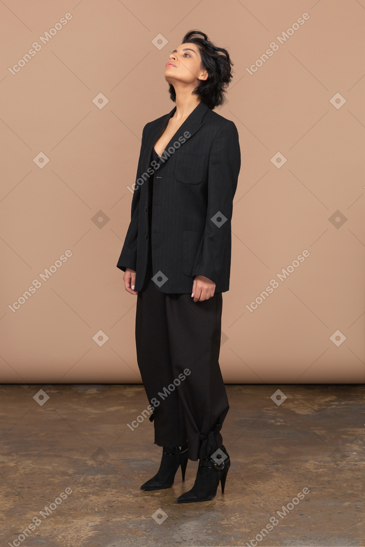 A woman wearing a black suit and high heels