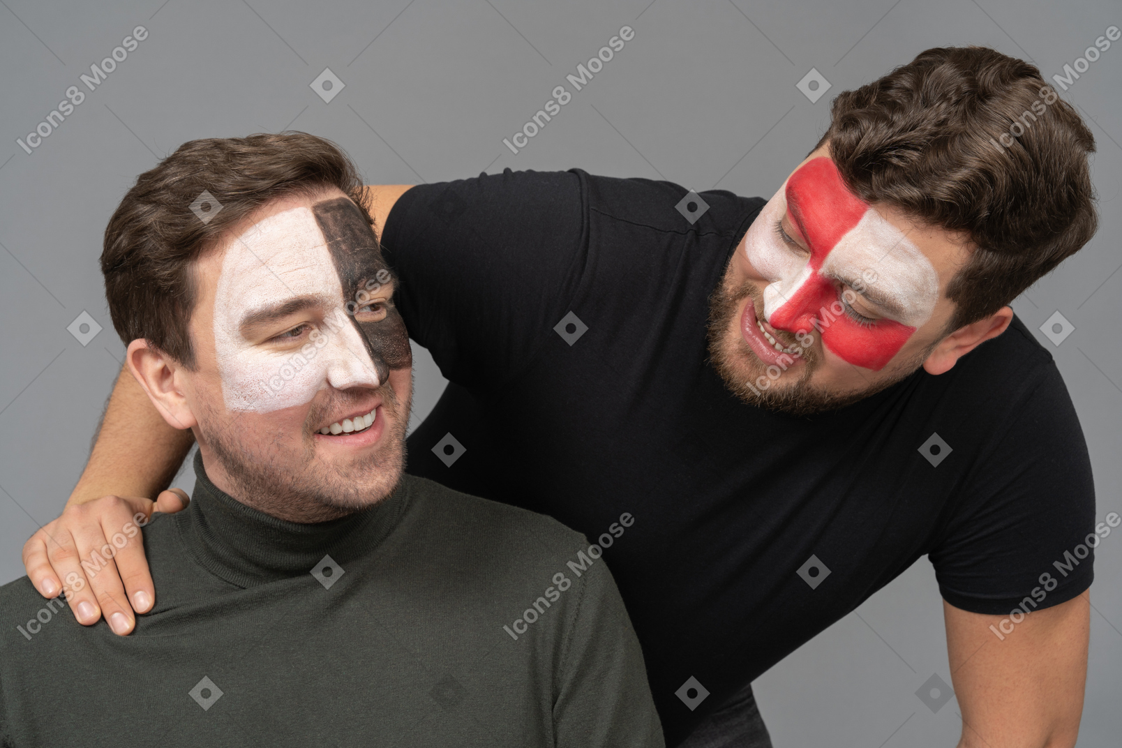 Front view of two cheerful male football fans with face art