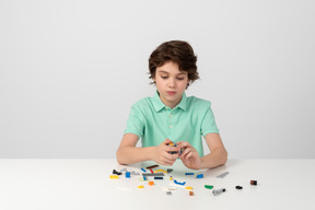 Teen boy playing with construction set