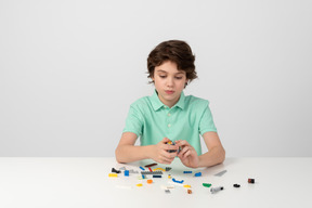 Teenager-junge spielt mit baukasten