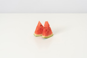 Two slices of a sweet ripe watermelon, lying isolated against a white background, tasty and natural