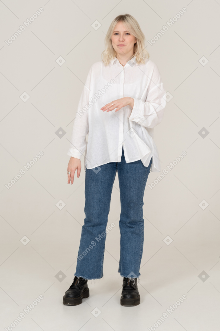 Front view of a blonde female in casual clothes grimacing and gesticulating