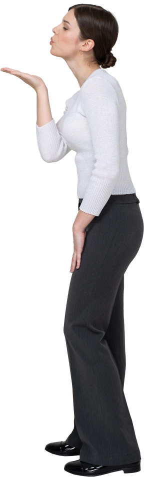 Side view of a young woman in office clothing sending an air kiss