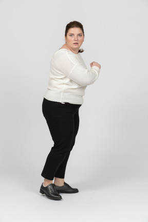 Scared plus size woman in casual clothes looking at camera